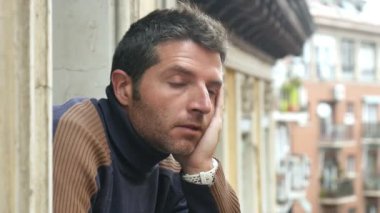 umutsuz ve depresyon kavramı ve sorunları için endişe uzaktan üzgün ve depresyonda öfkeli seyir balkonda genç üzgün adam yakın cam 4 k 24 kare/sn video elini tuttum 