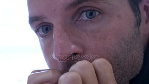 4k 24 fps close up blue eyes and hands of young sad unshaven man at home sitting in front of window looking sad and depressed suffering depression concept and problems — стоковое видео