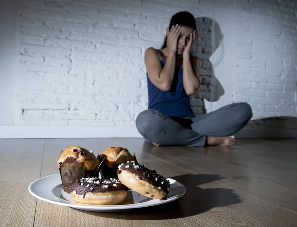 Rosquillas de azúcar poco saludables y magdalenas y tentada mujer joven o te — Foto de Stock