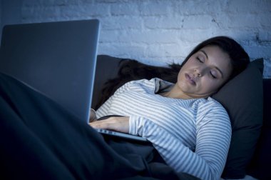 Pijama yatak ev yatak uyuyor, güzel İspanyol internet bağımlısı genç kadında