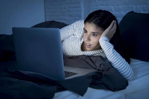 Γυναίκα Πυτζάμες στο κρεβάτι στο σπίτι υπνοδωμάτιο εργασίας συγκεντρώνεται με φορητό υπολογιστή αργά τη νύχτα — Φωτογραφία Αρχείου