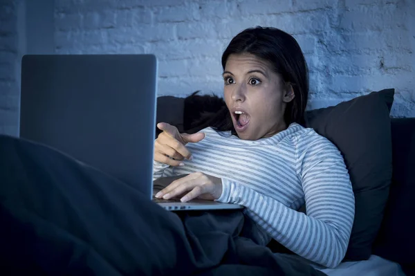 Femme en pyjama sur le lit à la maison chambre à coucher travailler concentré avec ordinateur portable tard dans la nuit — Photo