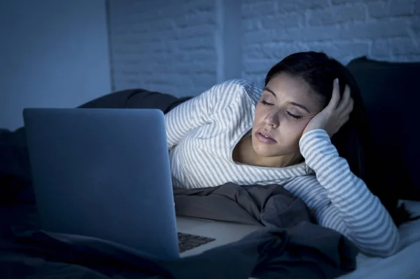 Fiatal gyönyörű spanyol internet rabja nő pizsamában otthon hálószoba alszik az ágyban — Stock Fotó