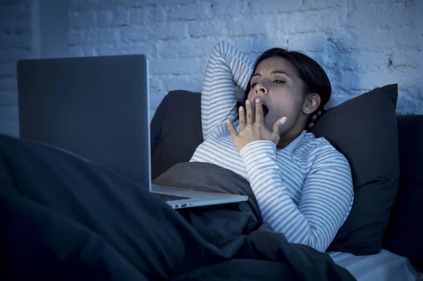 Jovem bela hispânico internet viciado mulher na cama com computador laptop bocejando cansado — Fotografia de Stock