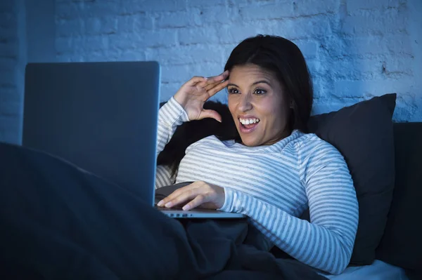 Fiatal gyönyörű spanyol nő ágyban otthon nevetve boldog-a laptop számítógép-éjjel — Stock Fotó