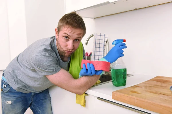 Joven triste frustrado hombre lavado y limpieza fregadero de la cocina del hogar — Foto de Stock