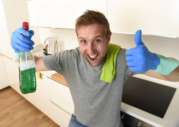 Щасливий незахищений чоловік в гумових рукавичках, що тримає миючий засіб для очищення спрею, посміхаючись впевнено — стокове фото