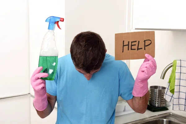 Messy man in stress in washing gloves holding detergent spray bottle asking for help — Stock Photo, Image
