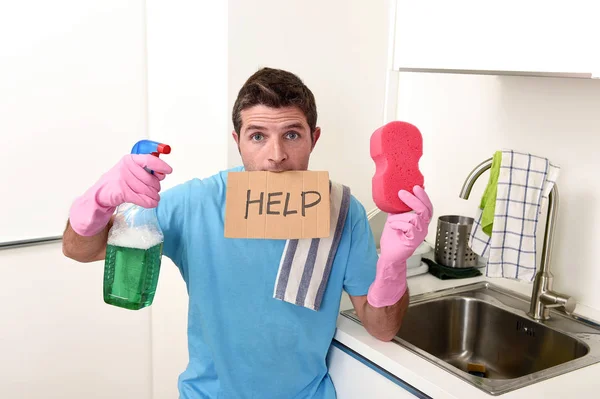 Messy man in stress in washing gloves holding sponge and detergent spray bottle asking for help — Stock Photo, Image
