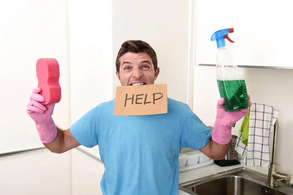 Грязный человек в стрессе в стирке перчаток с губкой и бутылкой с моющим средством с просьбой о помощи — стоковое фото