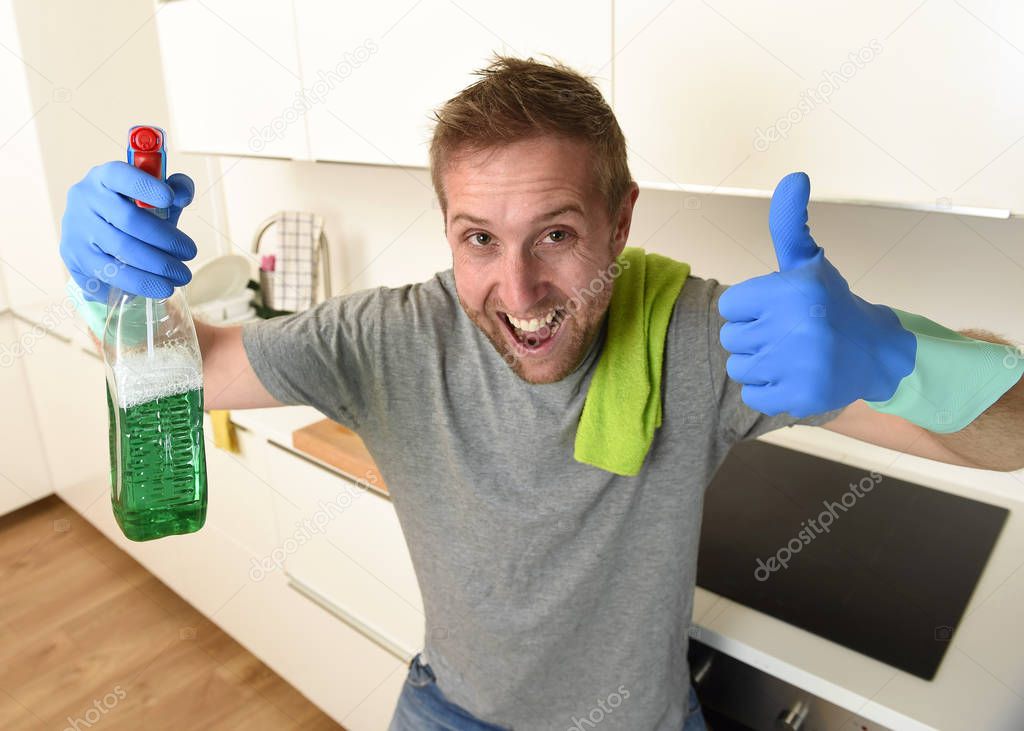 happy unshaven man in rubber washing gloves holding detergent cleaning spray smiling confident