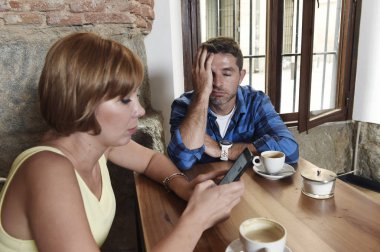 Genç çift internet ve cep telefonu ile kahve dükkanında sinirli adam kadın bağımlısı 