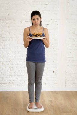 vücut ağırlığı ile şeker kek ve çikolata çörek tepsisi tutan ölçekte kontrol kız