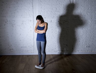 üzgün ve umutsuz genç fit ve ince kadın vücut ağırlığı ile büyük sinirli gölge ölçekte kontrol ışık 