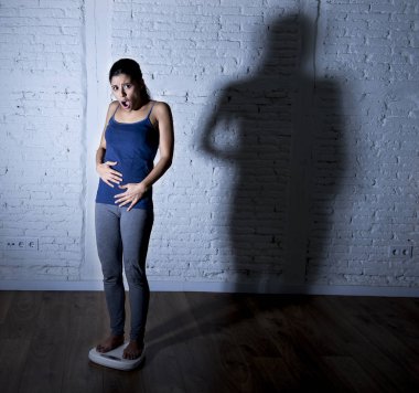 üzgün ve umutsuz genç fit ve ince kadın vücut ağırlığı ile büyük sinirli gölge ölçekte kontrol ışık 