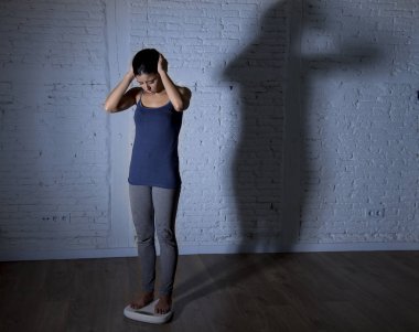 üzgün ve umutsuz genç fit ve ince kadın vücut ağırlığı ile büyük sinirli gölge ölçekte kontrol ışık 