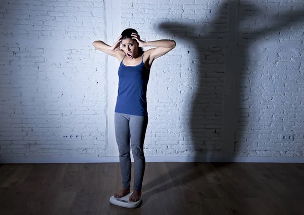 Üzgün ve umutsuz genç fit ve ince kadın vücut ağırlığı ile büyük sinirli gölge ölçekte kontrol ışık — Stok fotoğraf