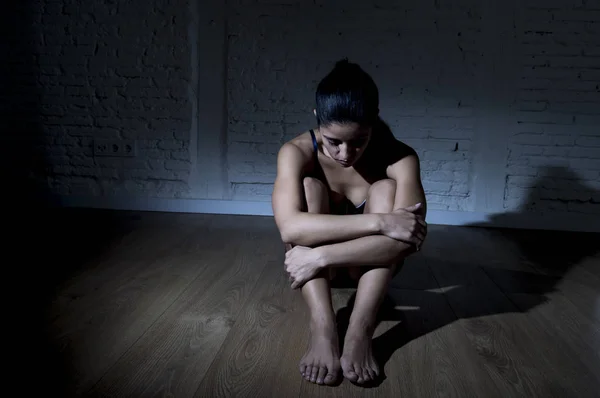 Junge schöne lateinamerikanische Frau oder Teenager-Mädchen, die traurig und allein in kantiger Dunkelheit sitzen und sich deprimiert fühlen — Stockfoto