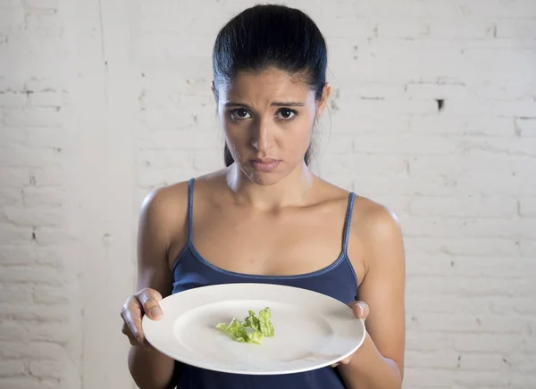 Mujer joven sosteniendo el plato con lechuga ridícula como su símbolo de alimentación de la dieta loca trastorno nutricional —  Fotos de Stock