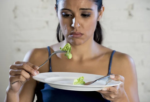 Mujer joven sosteniendo el plato con lechuga ridícula como su símbolo de alimentación de la dieta loca trastorno nutricional — Foto de Stock