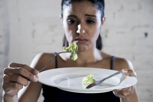 Junge Frau hält Gericht mit lächerlichem Salat als ihr Lebensmittel-Symbol für verrückte Ernährungsstörung — Stockfoto