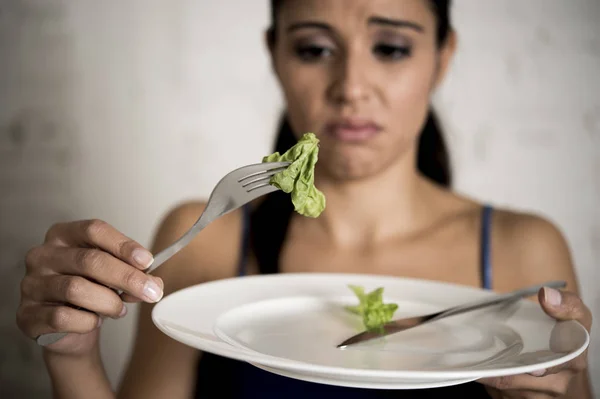 Mujer joven sosteniendo el plato con lechuga ridícula como su símbolo de alimentación de la dieta loca trastorno nutricional — Foto de Stock