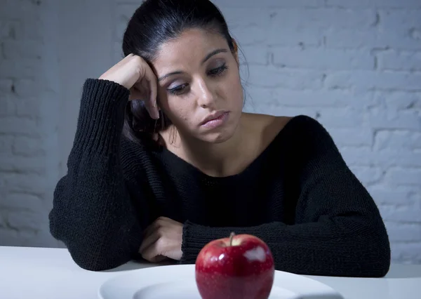 Mujer joven o adolescente buscando fruta de manzana en el plato como símbolo de la dieta loca en el trastorno nutricional — Foto de Stock