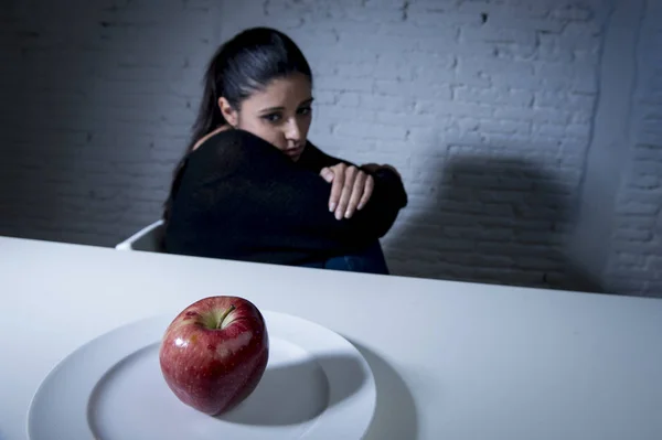 Mujer joven o adolescente buscando fruta de manzana en el plato como símbolo de la dieta loca en el trastorno nutricional — Foto de Stock