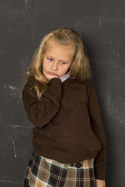 Mooie blonde schoolmeisje triest humeurig en moe voor school klasse bord — Stockfoto