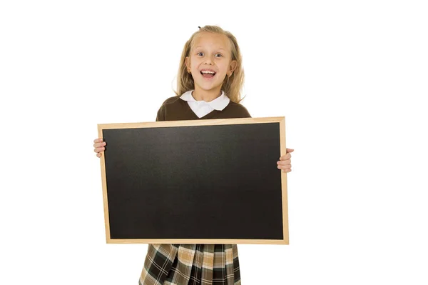 Pequeña hermosa rubia colegiala sonriendo feliz y alegre celebración y mostrando pequeña pizarra en blanco — Foto de Stock