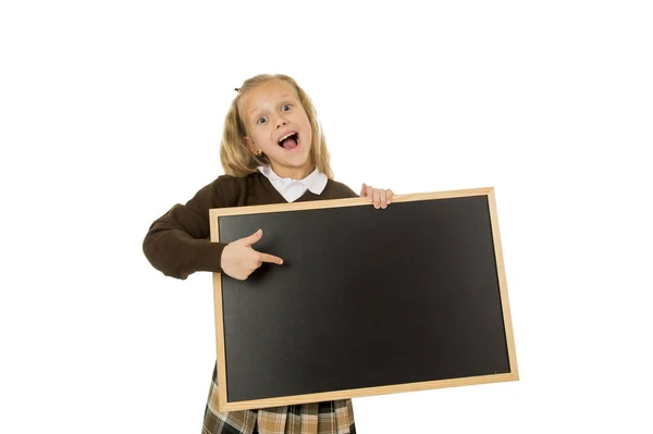 Pequeña hermosa rubia colegiala sonriendo feliz y alegre celebración y mostrando pequeña pizarra en blanco — Foto de Stock