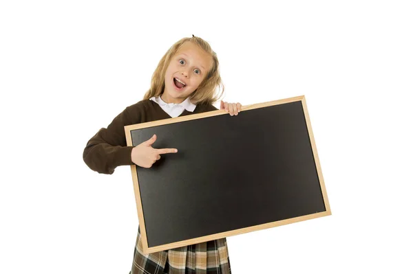 Malá krásná blond školačka, usmíval se šťastný a veselý holding a ukazuje malé prázdné tabule — Stock fotografie