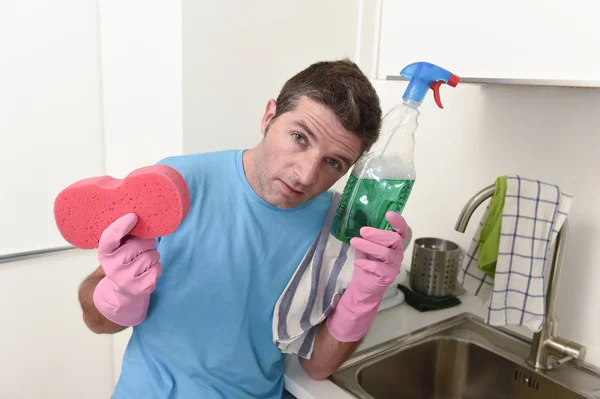 Молодий ледачий прибиральник будинку миє і прибирає кухню, втомившись від стресу — стокове фото