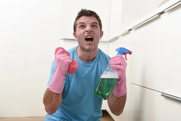 Молодой ленивый уборщик дома человек стирает и убирает кухню устал от стресса — стоковое фото