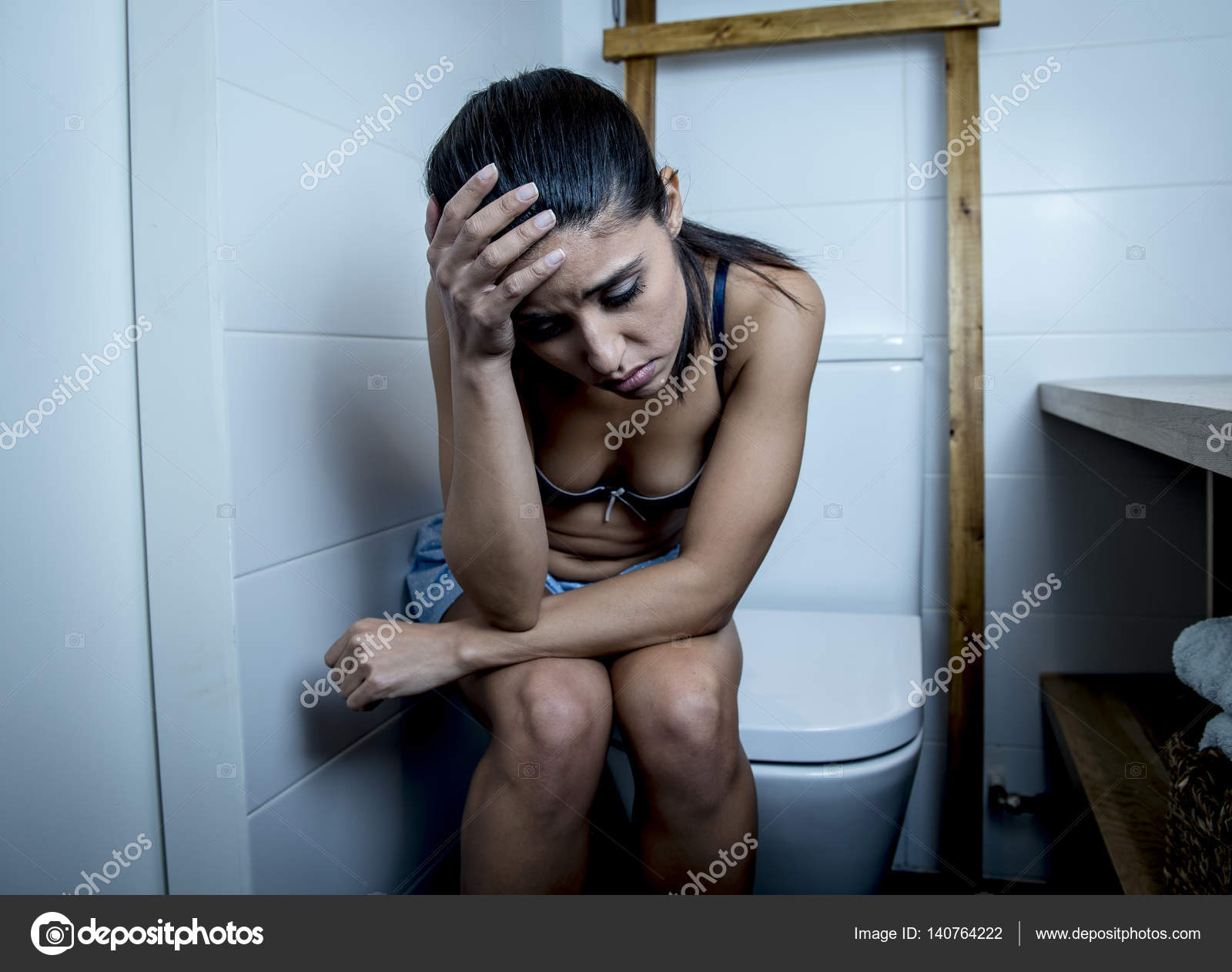 Young sad and depressed bulimic woman feeling sick sitting in toilet WC  looking desperate and ill Stock Photo by ©focuspocusltd 140764222