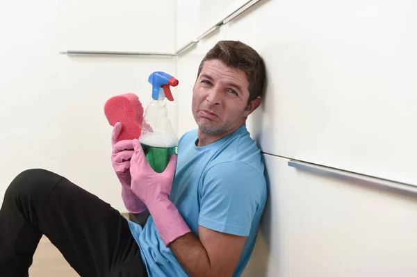 Young lazy house cleaner man washing and cleaning the kitchen tired in stress — Stock Photo, Image