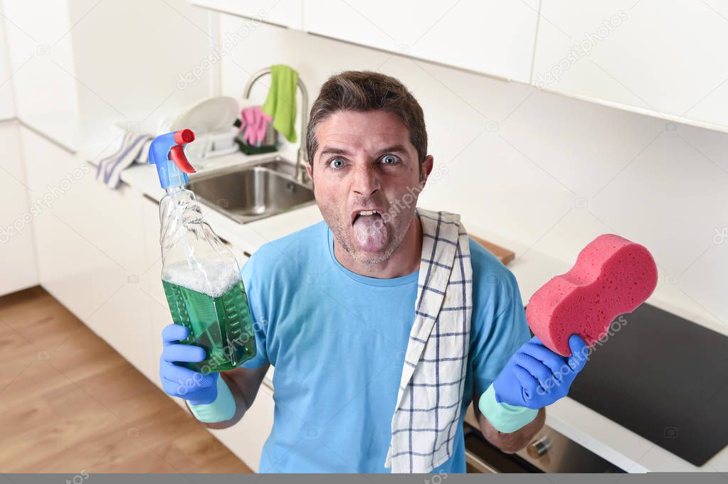 young lazy house cleaner man washing and cleaning the kitchen with detergent spray bottle