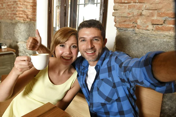 Pareja tomando foto selfie con el teléfono móvil en la cafetería sonriendo feliz en romance concepto de amor —  Fotos de Stock