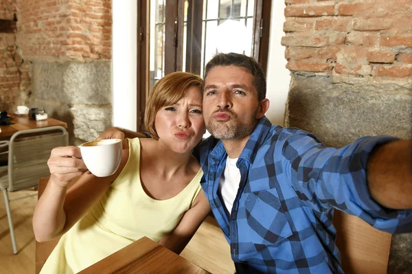 Pár pořízení selfie fotografie s mobilním telefonem v kavárně s úsměvem šťastný v pojetí lásky romance — Stock fotografie