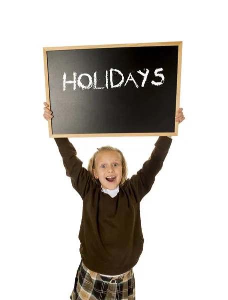 Schoolgirl smiling happy holding and showing blackboard with text holidays in end of school — Stock Photo, Image