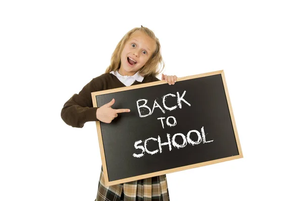 Écolière souriant heureux tenant et montrant petit tableau noir avec texte retour à l'école — Photo
