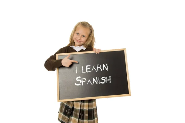 Schoolmeisje glimlachend gelukkig en vrolijk te houden en tonen kleine bord met de tekst dat ik Spaans leren — Stockfoto