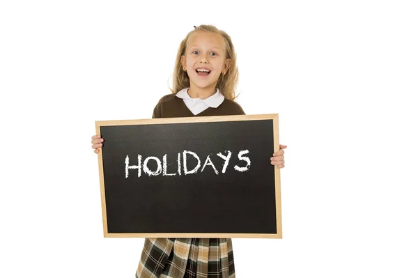 Écolière souriant heureux tenant et montrant tableau noir avec des vacances de texte à la fin de l'école — Photo