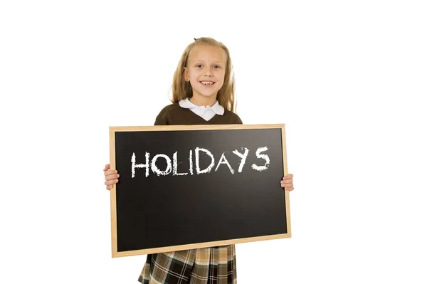 Schoolgirl smiling happy holding and showing blackboard with text holidays in end of school — Stock Photo, Image