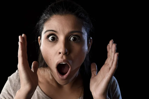 Giovane bella spaventata donna spagnola in shock e sorpresa faccia espressione isolata su nero — Foto Stock