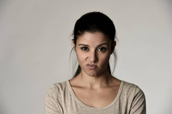 beautiful arrogant and moody hispanic woman showing negative feeling and contempt facial expression