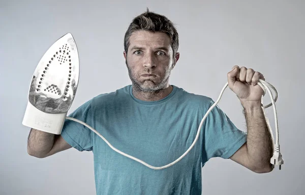 Young crazy desperate and frustrated man doing housework holding — Stock Photo, Image