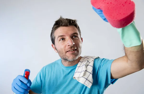 Zapracowanego męża uśmiechający się zadowolony robi sprzątanie domu z butelki w aerozolu i gąbki do mycia szkła — Zdjęcie stockowe