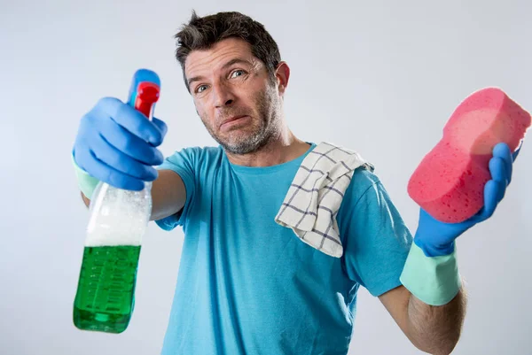 Servicio doméstico hombre o marido cansado enojado y estresado limpieza de la casa con aerosol botella y esponja — Foto de Stock