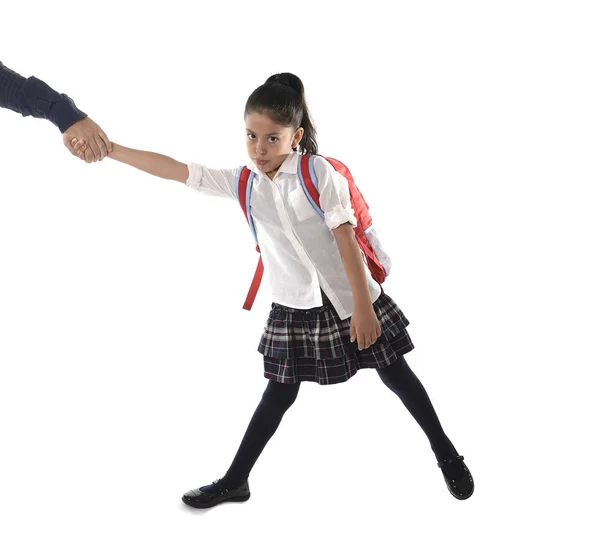 Far hand hålla och dra sin unga lynnig latin skolflicka med uniform och ryggsäck arg — Stockfoto